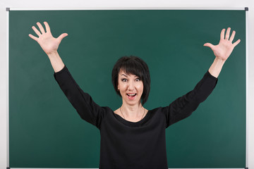 teacher having idea and posing by chalk Board, learning concept, green background, Studio shot