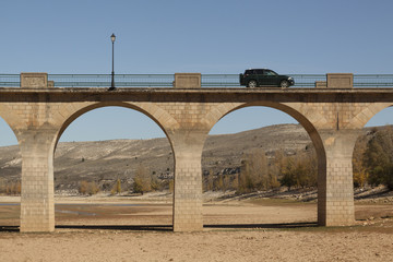 Fototapeta na wymiar Drought in the Linares reservoir. Bridge of Maderuelo in Segovia, Castilla y Leon. Spain