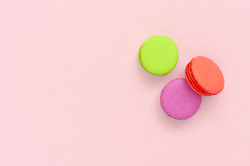 Cake macaron or macaroon on pink background top view flat lay, beautiful dessert, colorful almond cookies, pastel colors, vintage card