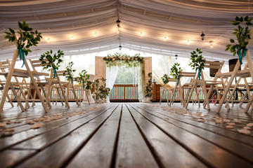 Wedding arch for wedding ceremony. Beautiful wedding decor in rustic style and chairs for guests