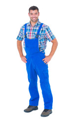 Fototapeta premium Handyman in coveralls standing hands on hip over white background