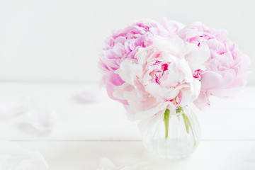 Fresh bunch of pink peonies on white wooden background