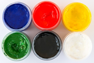 Color gouache jars on white background. Top view.