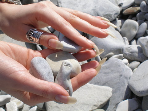 Woman Hands With Long Finger Nails Holding Stones