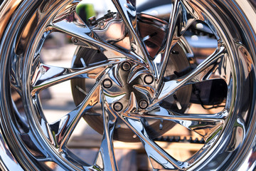 Motorcycle close-up. Detail of a beautiful powerful chrome motorcycle wheels. The concept of freedom and travel. custom works. Metallic shiny new internal combustion engine