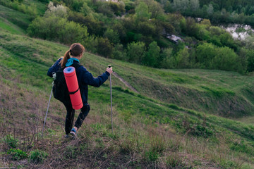 Hiking girl is coming down the slope