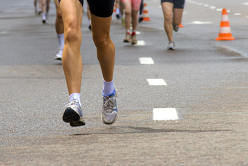 Fototapeta na wymiar Female runner legs outdoors, leading in marathon