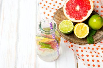 Infused flavored water with fresh fruits on white wooden background.Refreshing summer homemade  detox water