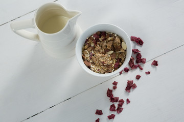 Bowl of breakfast cereals with dried fruits and jug 