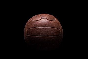 Old football leather ball on a black background