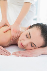 Fototapeta na wymiar Beautiful woman enjoying shoulder massage at beauty spa