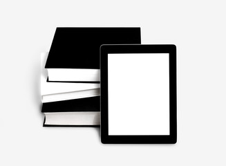 Blank tablet or e-book and pile of old books 