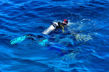 Divers on the clear and turquoise Red Sea on immersion in beautiful corals and colorful fish. The teacher teaches the student the rules of immersion in water. Summer, vacation. Egypt