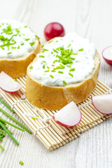 Obraz na płótnie Canvas Bread with cheese spread, chives and radishes. healthy breakfast concept. 