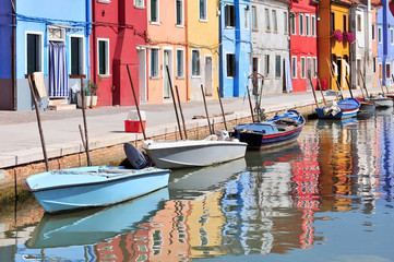 Fototapeta na wymiar Small colored houses and the boats in sunny summer day, Venice Burano island.