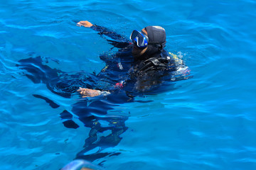 Divers on the clear and turquoise Red Sea on immersion in beautiful corals and colorful fish. The teacher teaches the student the rules of immersion in water. Summer, vacation. Egypt