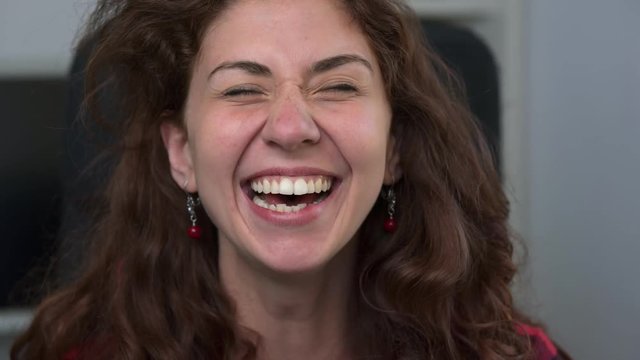 Pretty young woman laughing at camera- close up