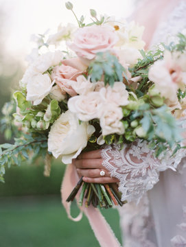 Mid section of a bride holding a flower bouquet