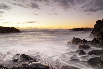 Volcanic beach with stones just after sunset, water movement in long exposure - Location: Spain, Canary Islands, La Palma