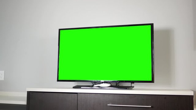 A 4K TV set on top of a modern dresser in ambient room