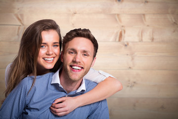 Fototapeta premium Close up of happy young couple against bleached wooden planks background
