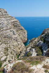 Wied Babu, at Wied iz-Zurrieq, green rocky valley, leading down to the azure turquoise water of the Blue Grotto, Zurrieq, Malta, May 2017
