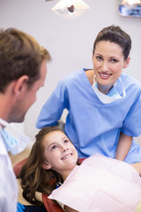 Smiling dentists interacting with young patient