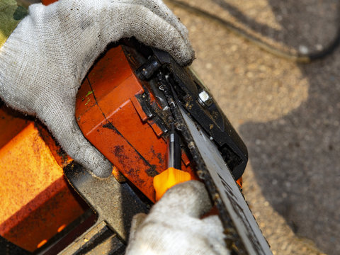 tensioning the chain of a chainsaw - Powered by Adobe