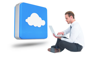 Smiling businessman sitting on floor using laptop against cloud computing tile