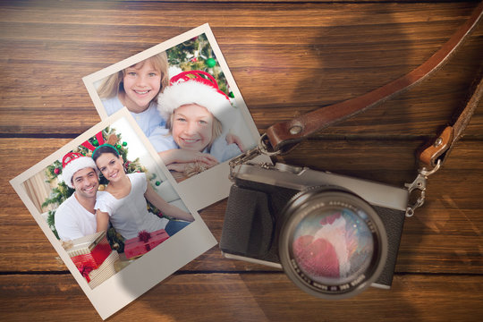Composite image of christmas memories against instant photos on wooden floor