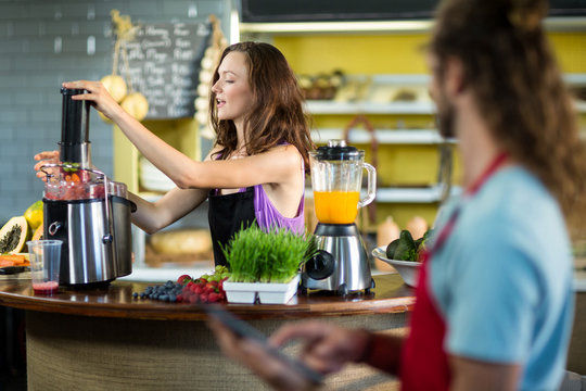 Shop assistant preparing juice at health grocery shop - Powered by Adobe