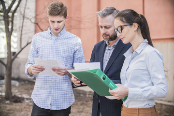 a group of businessmen discussing business plans on the street