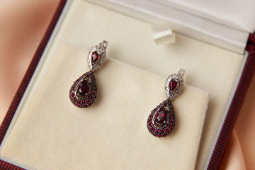 Pair of ruby diamond earrings in jewelry box, close-up. Beautiful luxury brilliant jewelry