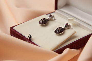 Pair of ruby diamond earrings in jewelry box, close-up. Beautiful luxury brilliant jewelry