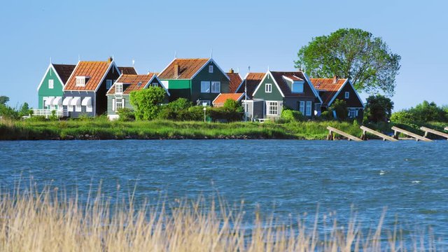 Typical colorful Dutch houses in the small village of Marken with the Marermeer lake in the foreground / Marken, North Holland, Netherlands. Shot with RED Weapon Helium 8K camera.