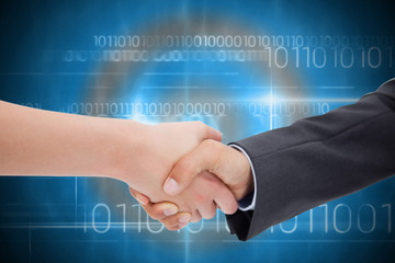Close up of a handshake against blue technology design with binary code