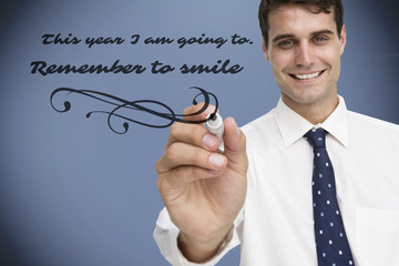 Smiling businessman holding marker against grey vignette