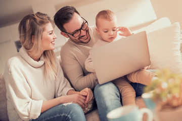 Young family watching cartoon on laptop together