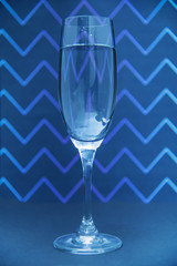Glass of champagne on zig zga pattern background