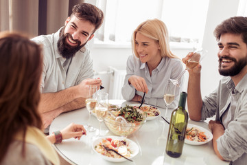 Positive happy young people enjoying food at home