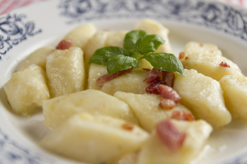 Homemade cottage cheese gnocchi or vareniki or kopytka. Traditional dish in many countries. Polish version with  pork scratching. Made form potatoes,fluor and cottage cheese. Selective focus.