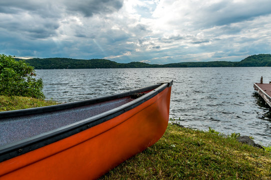 Bright Red Canoe Lakeside In The Early Evening Hours With A Back Lit Cloudy Sky Stock Photo Adobe Stock Bright Red Canoe Lakeside In The Early Evening Hours With A Back Lit Cloudy Sky Stock Photo Adobe Stock