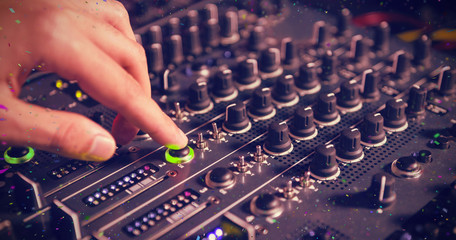 Male DJ playing music against flying colours