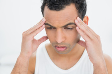 Closeup of a young man suffering from headache