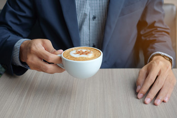 Business man holding and drinking hot coffee in office