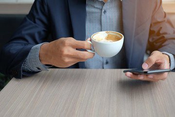 Businessman using smart phone and drinking hot coffee in office. business, technology and communication concept