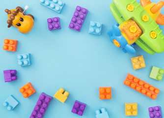 Colorful kids toys frame on blue background. Top view for copy space