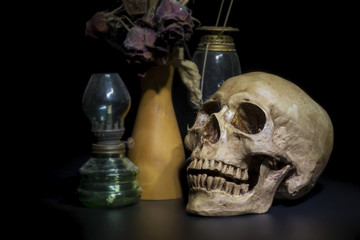 Still life photography with human skull on dark background