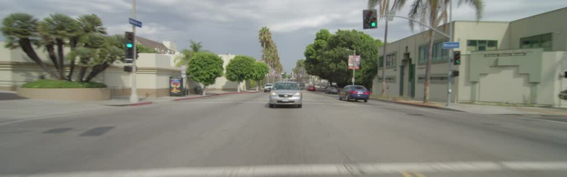 Rear view of a Driving Plate. Car travels west on Melrose Avenue from Windsor Boulevard to cross Larchmont Boulevard in Los Angeles, California.