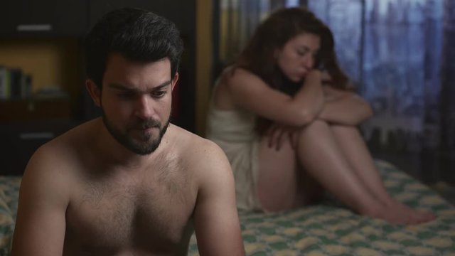 Male impotence: sad and silent  couple in the bedroom 